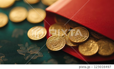 Gold coins spilling from a red envelope on a textured surface. 123016497