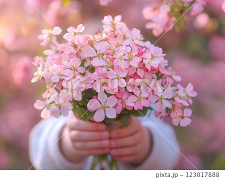 child joyfully carries bouquet of wildflowers during spring parade surrounded blooming trees capturing essence of spring and celebration in vibrant atmosphere. 123017888