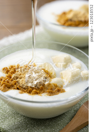 きな粉トッピングしたバナナヨーグルトにオリゴ糖をかける 123018552