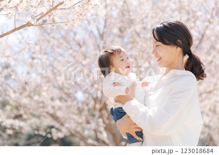 桜の咲く公園で遊ぶ母と娘 桜の咲く公園で遊ぶ母と娘 123018684