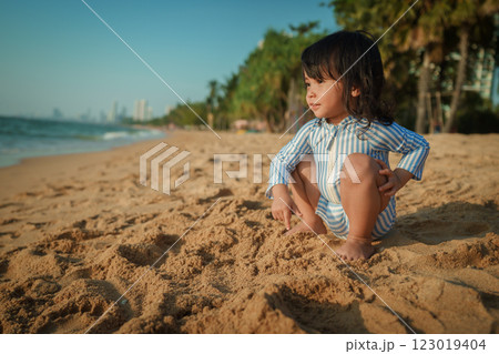 toddler baby girl sitting on sea beach in Pattaya, Thailand 123019404