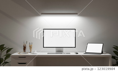 A minimalist white office features a computer and a digital tablet set on a desk. 123019984
