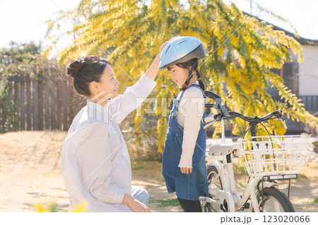 ヘルメットを被らせるママと女の子 123020066