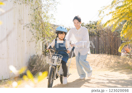 自転車に乗る練習をする親子 123020098
