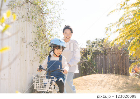 自転車に乗る練習をする親子 123020099