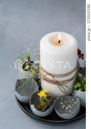 Creative handmade Easter table decoration with egg shells instruction candle on grey background. Easter home decoration. Copy space greeting card Seasonal sustainable recycled Creative handmade Easter table decoration with egg shells instruction candle on grey background. Easter home decoration. Copy space greeting card Seasonal sustainable recycled 123020398