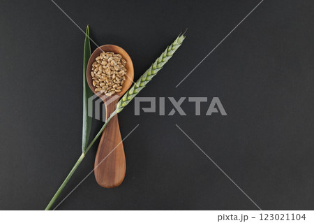 Wooden Spoon Filled With Wheat Grains on Rustic Background 123021104