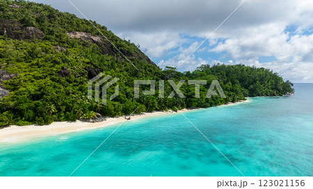Green hillside meets turquoise waters, with a white sand beach stretching along the coast. Therese. Seychelles, Mahe. 123021156