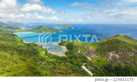 Coastal landscape with turquoise bays, lush green hills and distant islands under a cloudy sky. Seychelles, Mahe. Coastal landscape with turquoise bays, lush green hills and distant islands under a cloudy sky. Seychelles, Mahe. 123021173