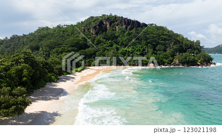 A tropical beach paradise with golden sands, crystal-clear waters, and lush green foliage. Seychelles, Mahe. Anse Louis beach. A tropical beach paradise with golden sands, crystal-clear waters, and lush green foliage. Seychelles, Mahe. Anse Louis beach. 123021198