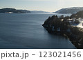 A serene winter landscape featuring a deep blue fjord 123021456