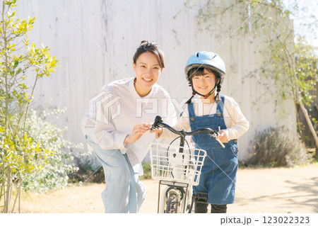 自転車に乗る練習をする親子 123022323