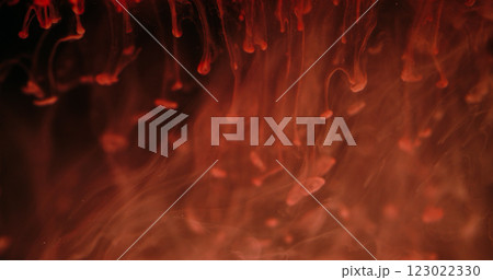 Falling paint drop. Blur fog ink. Defocused red orange color shine liquid flow fluid smoke mist texture wave on abstract art dark black background. 123022330