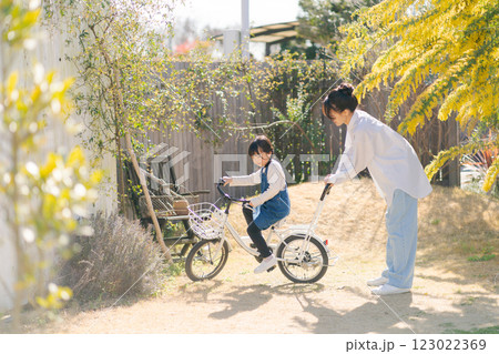自転車に乗る練習をする親子 123022369