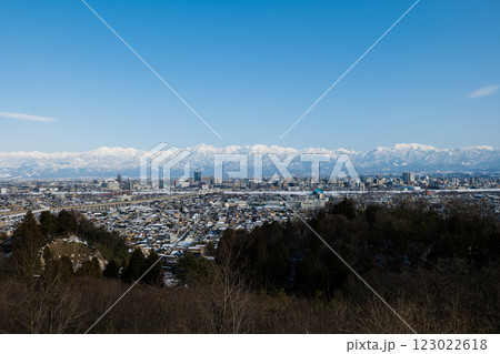冠雪の北アルプス剱岳、薬師岳、立山連峰と雪化粧の富山市街地 123022618