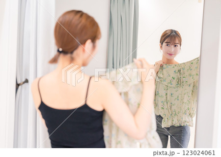 試着室で服の試着をする若い女性 試着室で服の試着をする若い女性 123024061