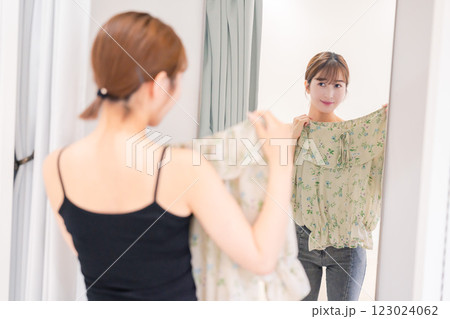 試着室で服の試着をする若い女性 試着室で服の試着をする若い女性 123024062