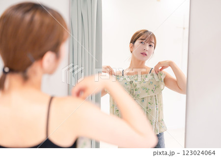 試着室で服の試着をする若い女性 123024064