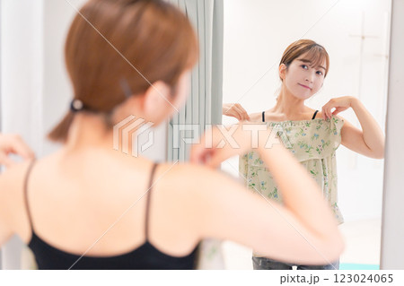 試着室で服の試着をする若い女性 試着室で服の試着をする若い女性 123024065
