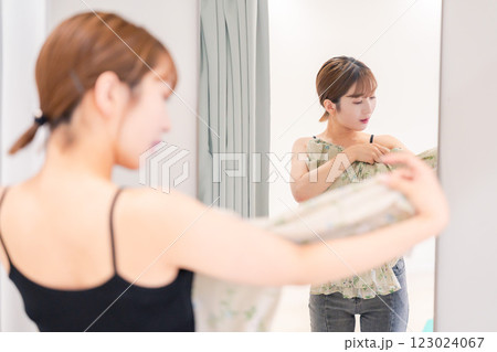 試着室で服の試着をする若い女性 試着室で服の試着をする若い女性 123024067
