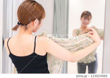試着室で服の試着をする若い女性 123024069
