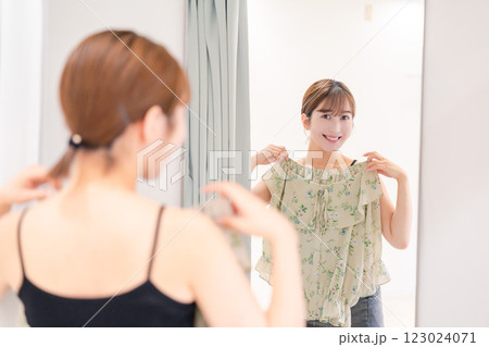 試着室で服の試着をする若い女性 123024071