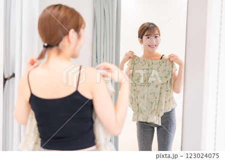 試着室で服の試着をする若い女性 123024075