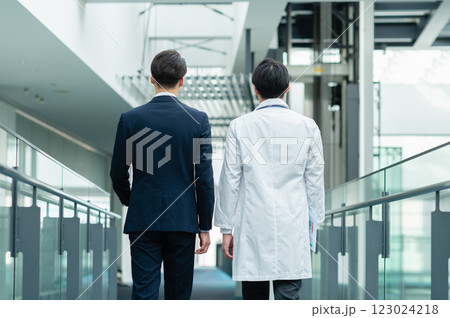 廊下を歩くビジネスマンと医師の後ろ姿【撮影協力:スカパー東京メディアセンター】 廊下を歩くビジネスマンと医師の後ろ姿【撮影協力:スカパー東京メディアセンター】 123024218