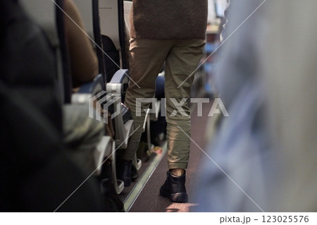 The man puts things on the shelf. Passengers sit along the row in the plane in their seats. The concept of travel. High quality photo 123025576
