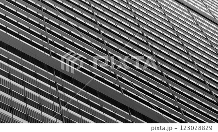 A striking black and white architectural facade with repetitive geometric patterns. The diagonal lines and shadows create depth, emphasizing the building modern design 123028829