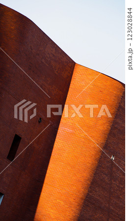 Curved brick architecture illuminated by sunlight creates a striking contrast between warm and shadowed tones. Curved brick architecture illuminated by sunlight creates a striking contrast between warm and shadowed tones. 123028844