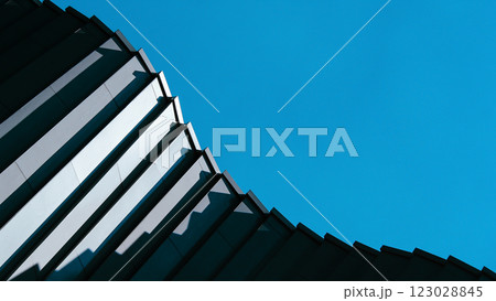 A repetitive glass facade creates a mesmerizing geometric pattern. The diagonal angle enhances depth and visual rhythm. 123028845