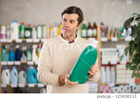 Man choosing cleaning product in supermarket Man choosing cleaning product in supermarket 123030113