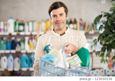 Adult man chooses household chemicals in store Adult man chooses household chemicals in store 123030136