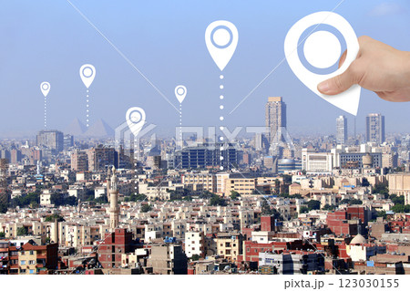 Planning a tourist trip. Top view of Cairo with Great Pyramids and hand with location pin. Travel way,  point navigation concept. Global positioning system pin map. Modern travel, sightsee, tourism 123030155