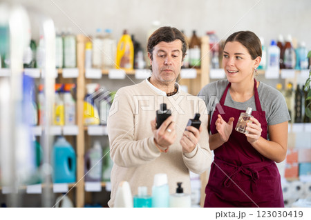 Female consultant helps man buyer choose perfume 123030419