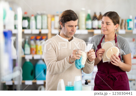 Friendly female sales consultant offering body sponges to customer Friendly female sales consultant offering body sponges to customer 123030441