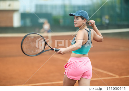 Emotional young girl enthusiastically playing tennis outdoors 123030443