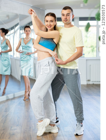 Smiling woman and man dancing bachata in choreography studio Smiling woman and man dancing bachata in choreography studio 123030573