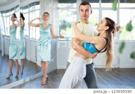 Couple in comfortable sports clothes waltz dancing during individual lesson 123030590