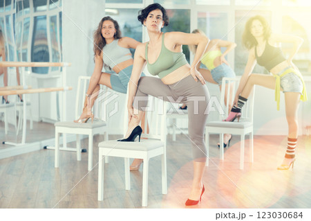 Hispanic woman performing high heels choreography with chair in dance studio Hispanic woman performing high heels choreography with chair in dance studio 123030684