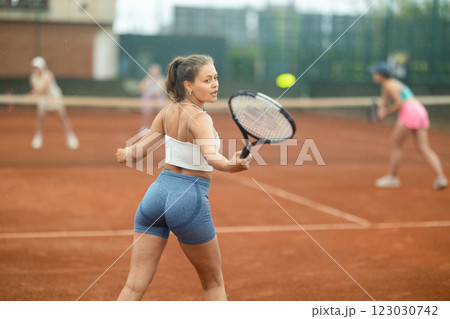 Two young women playing tennis against elderly women Two young women playing tennis against elderly women 123030742