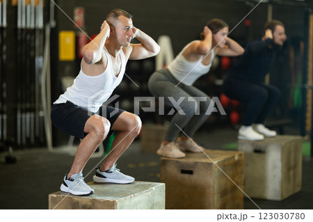 Man jumping up on box at functional cross training in gym Man jumping up on box at functional cross training in gym 123030780