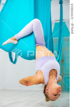 Group of women hang upside down in a hammock. Fly yoga class in gym. Fit and wellness lifestyle 123030814