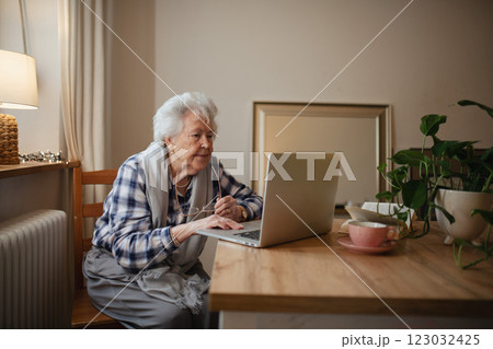 Senior woman working on laptop on her own, feeling confident. 123032425