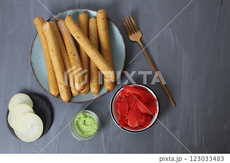 Served breakfast: Sausages on a plate with white sauce, red pickled ginger and white cheese, top view. Fast Car Concept 123033483