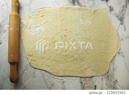 Rolled out layer of yeast dough on a table with flour 123033561