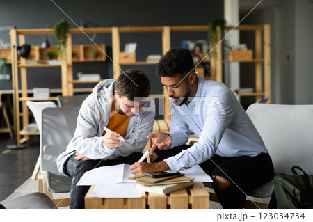 Young man with Down syndrome studyng with special educator teacher in special education classroom. 123034734