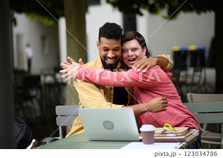 Young man with Down syndrome hugging his special educator teacher. Young man with Down syndrome hugging his special educator teacher. 123034786