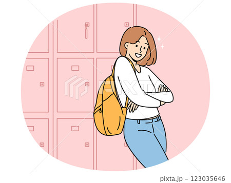 Woman student stands near boxes for personal items in college hallway and looks at screen smiling Woman student stands near boxes for personal items in college hallway and looks at screen smiling 123035646
